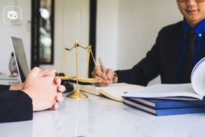 Advogado e cliente discutindo honorários sucumbenciais com balança da justiça
